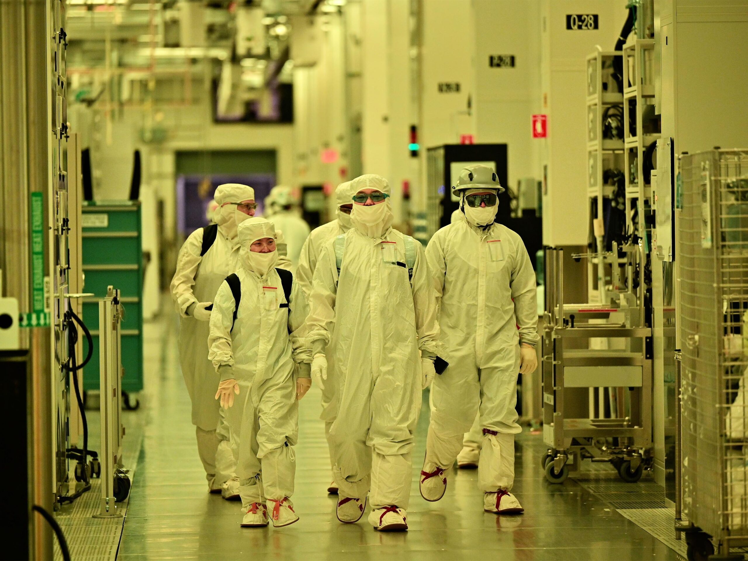 Intel workers wearing gowns inside the fab's cleanroom environment.